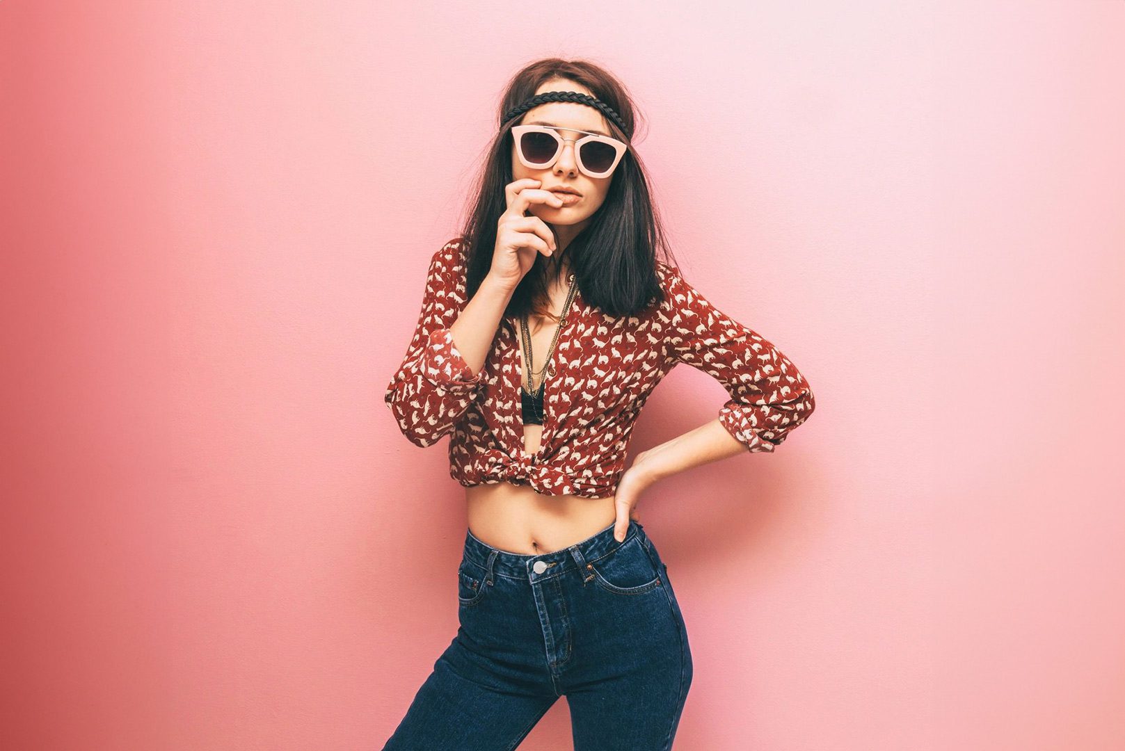 A woman in jeans and sunglasses posing for the camera.