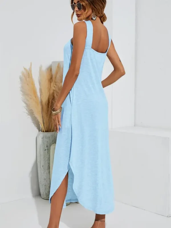 A woman wearing a blue sleeveless maxi dress.