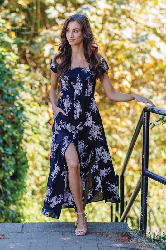 Woman wearing a blue floral off-shoulder maxi dress.