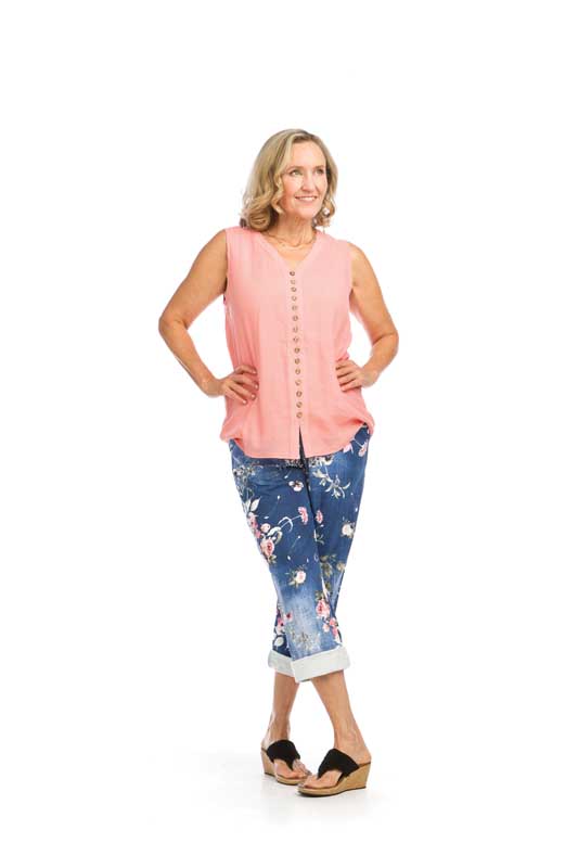 Woman wearing pink sleeveless blouse and floral capri pants.