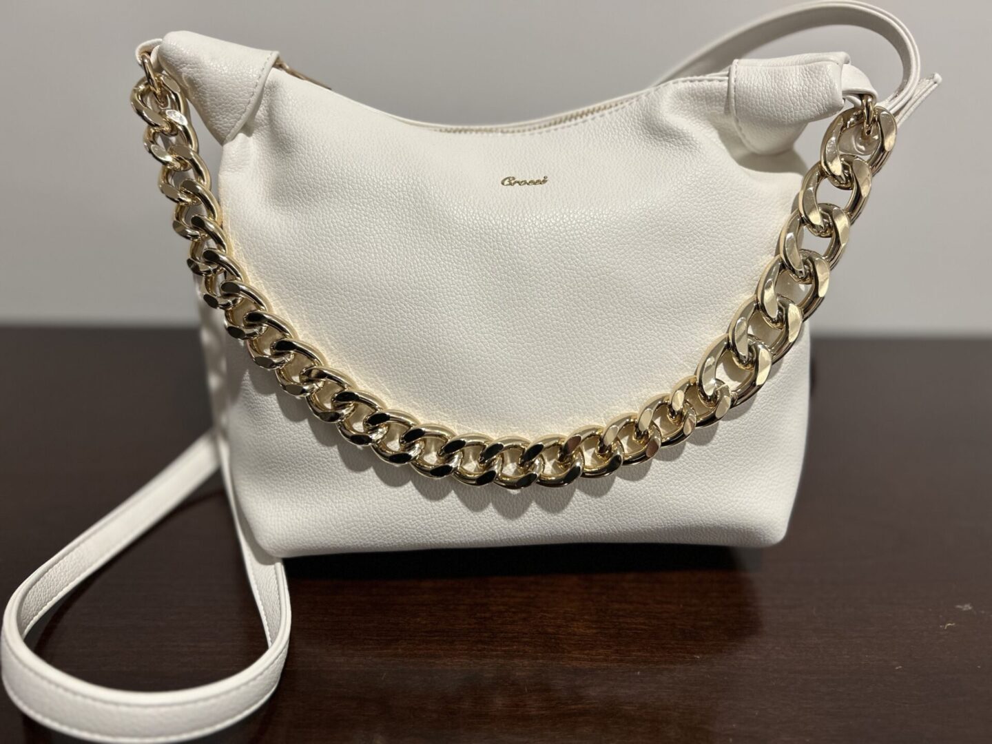 White purse with gold chain strap.