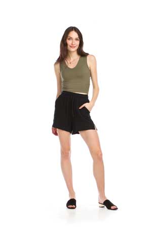 Woman in green tank top and black shorts.