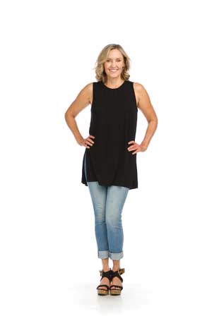 Woman in black tank top and jeans smiling.