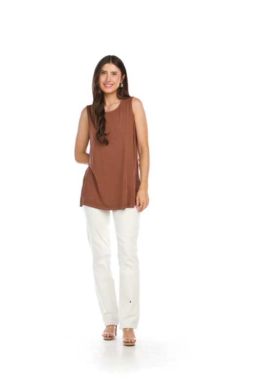 Woman in brown tank top and white pants.